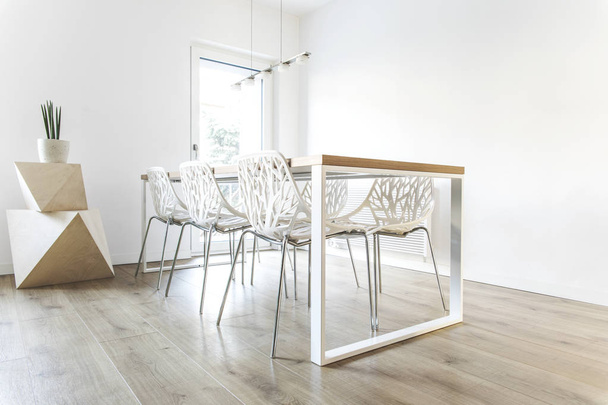 Современная столовая с деревянным столом и необычными белыми стульями
 - Фото, изображение