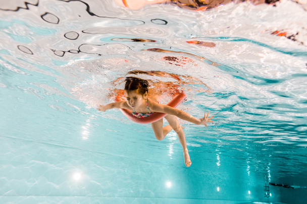 cute child with closed eyes swimming underwater in swimming pool  - Foto, immagini