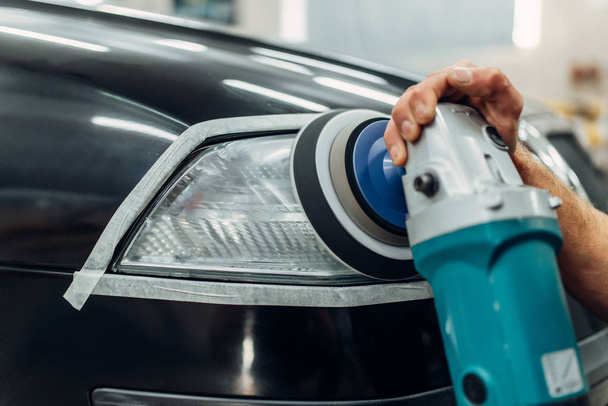 Détail automatique des phares de voiture sur le service de lavage de voiture. Travailleur nettoyage du verre avec machine à polir
 - Photo, image