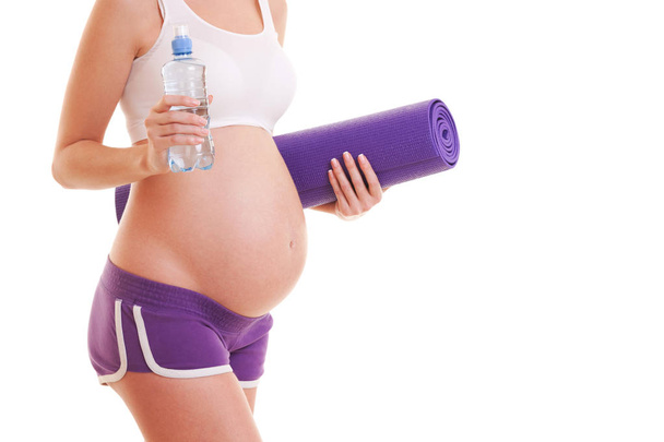 Beautiful pregnant woman with exercising mat and water on white background. Healthy lifestyle. Motherhood, pregnancy, people and expectation concept. Pregnant woman expecting baby - Foto, Bild