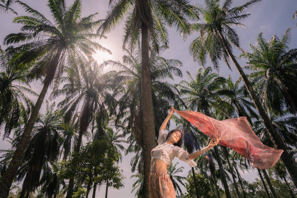 Solo Kaukasische vrouwelijke reiziger alleen te midden van palmbomen in Putrajaya, Maleisië - Foto, afbeelding