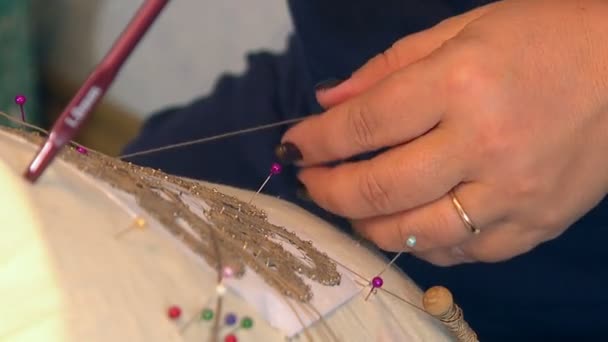 The village craftswoman spins a beautiful lace pattern from thin silk threads. - Кадры, видео