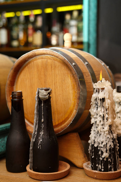 Bar counter decor - barrel, bottles as a candlestick - 写真・画像