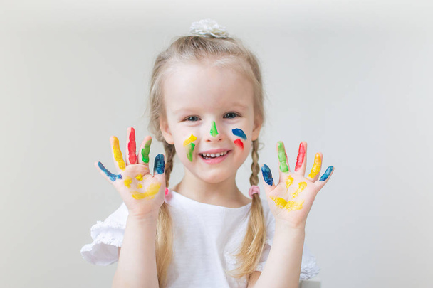 Eve erken eğitim okul okul öncesi geliştirme çocuk oyunu için hazırlanıyor, beyaz küçük kız boyama renkli elleri ile boyar - Fotoğraf, Görsel