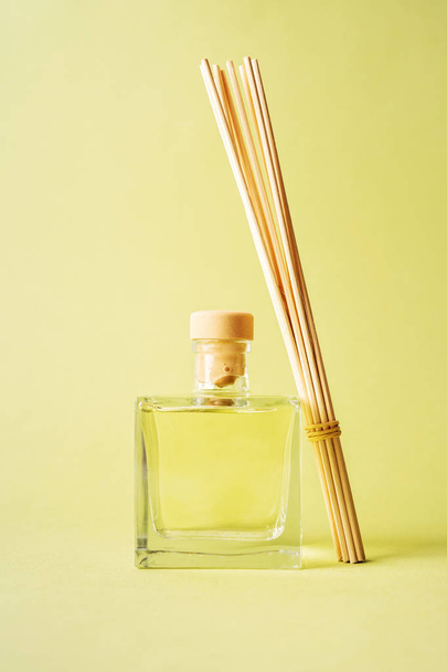 aroma reed fragrance diffuser with rattan sticks on light green background - Foto, imagen
