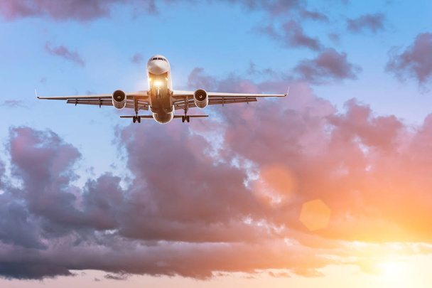 Самолет на глиссаде перед посадкой на фоне красивого заката и живописных облаков
 - Фото, изображение