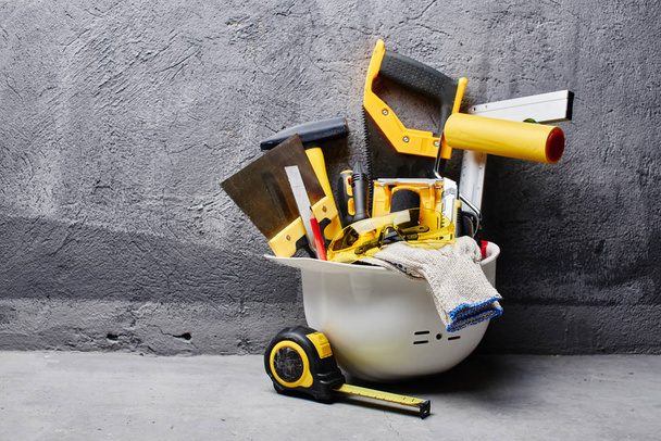 set of construction tools on a black wall background  - 写真・画像