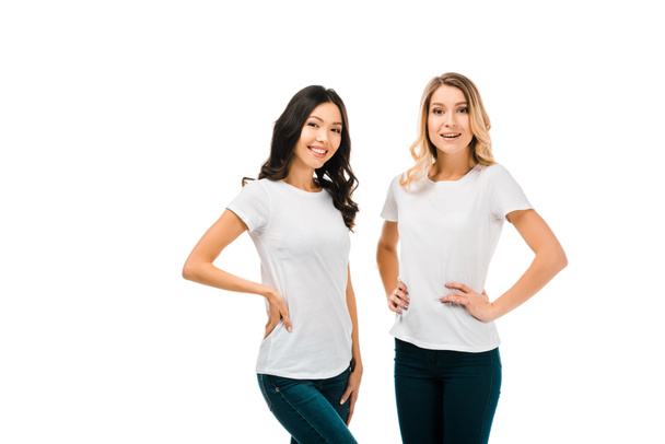 beautiful happy girls in white t-shirts standing together and smiling at camera isolated on white - Foto, imagen