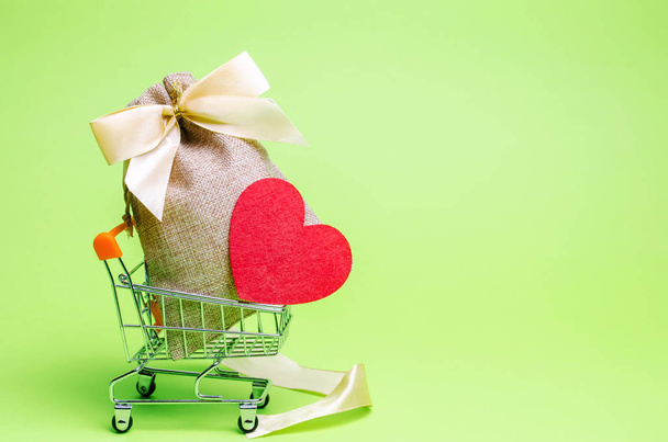 Bag with money and red heart. Valentine's Day. Saving money. Accumulation. Buying gifts to your loved one. Preparation for the holiday. Charity. Donation. Social help. Volunteering - Valokuva, kuva