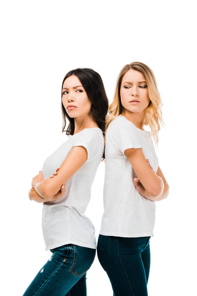 boční pohled rozrušená mladých žen stojí zády k sobě s překřížením rukou izolované na bílém   - Fotografie, Obrázek