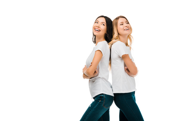side view of beautiful happy young women standing back to back and laughing isolated on white - Foto, immagini