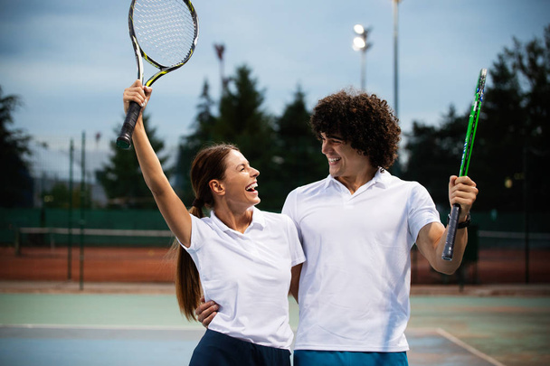 Happy fit people playing tennis together. Sport concept - Foto, afbeelding
