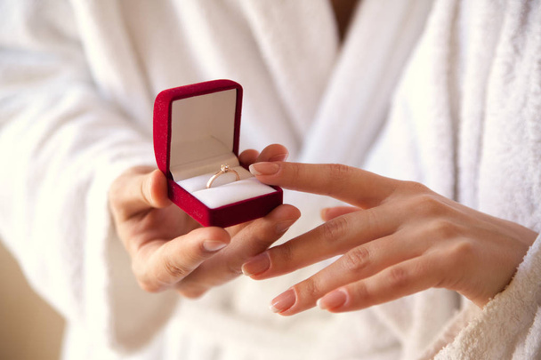 Heiratsantrag. die Hand hält eine rote Geschenkbox mit einem Goldring. Satz. der beste Tag. verleiht einen Ring. eine Berührung der Hände. Engagement. Valentinstag - Foto, Bild