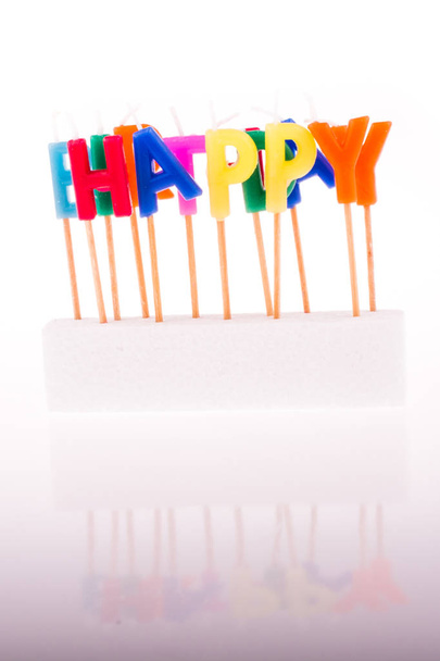 Color candles on sticks write the word happy - Photo, Image