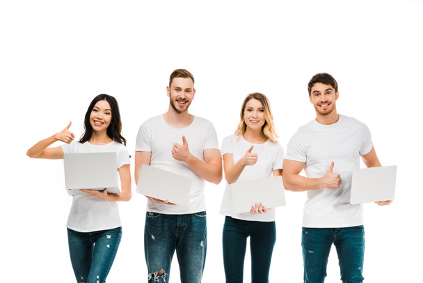 happy young people holding laptops and showing thumbs up isolated on white - Фото, изображение