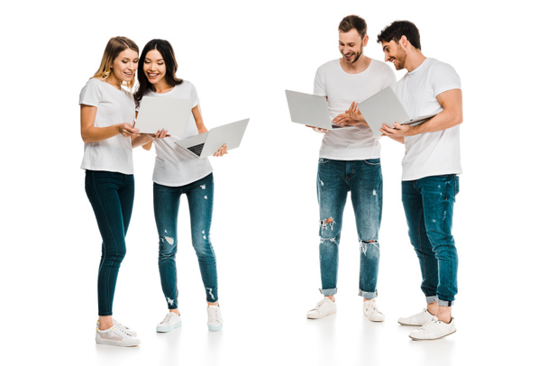 smiling young men and women standing together and using laptops isolated on white - Fotografie, Obrázek