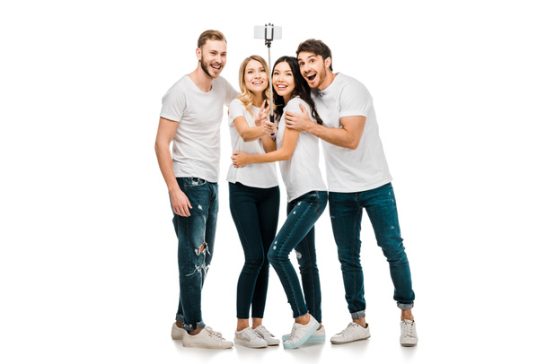 felices jóvenes amigos tomando selfie con smartphone y selfie stick aislado en blanco
 - Foto, imagen