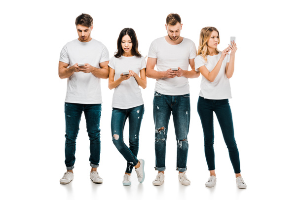 full length view of young friends in white t-shirts and jeans using smartphones isolated on white - Photo, Image