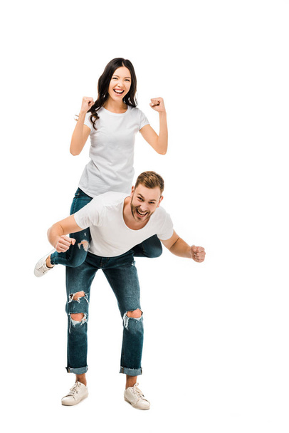 happy young couple piggybacking and smiling at camera isolated on white  - Fotó, kép