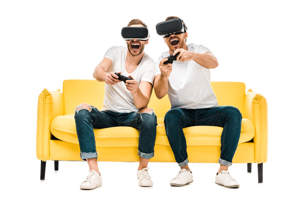 возбужденные молодые люди в наушниках виртуальной реальности, играющие с джойстиками, изолированными на белом
  - Фото, изображение