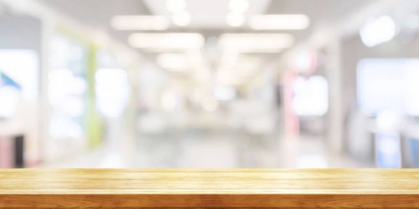 Κενό ξύλινο τραπέζι κορυφή με σύγχρονο εμπορικό κέντρο θολή φόντο. Πανοραμική πανό. Αφηρημένα φόντο μπορεί να χρησιμοποιηθεί οθόνης προϊόντος.  - Φωτογραφία, εικόνα