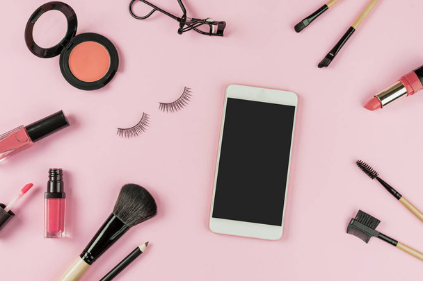Set of make up brushes and cosmetics on pink background with smart phone and copy space, Top view - Valokuva, kuva