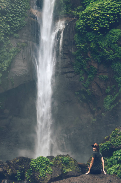 junge Frau posiert auf einem großen sekumpul-Wasserfall im tiefen Regenwald der Bali-Insel, Indonesien. - Foto, Bild