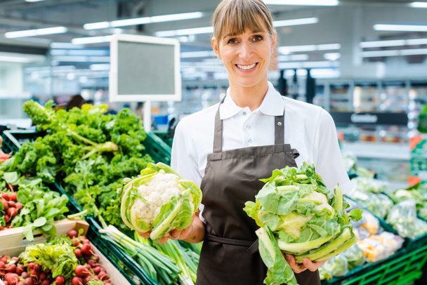 Asistente de tienda mujer en el supermercado mostrando los productos frescos
 - Foto, Imagen