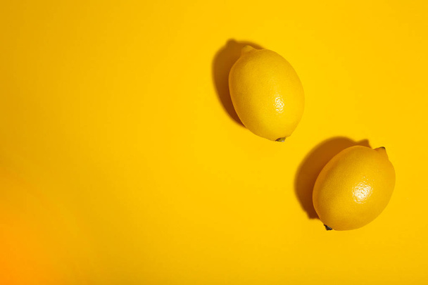 Two lemon on yellow background. Tropical fruit. - Foto, imagen