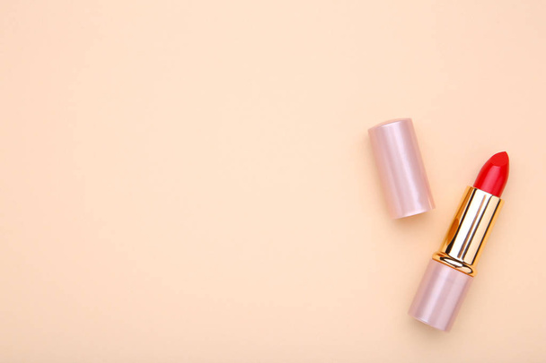 Red lipstick on beige background. Cosmetic, macro - Fotó, kép