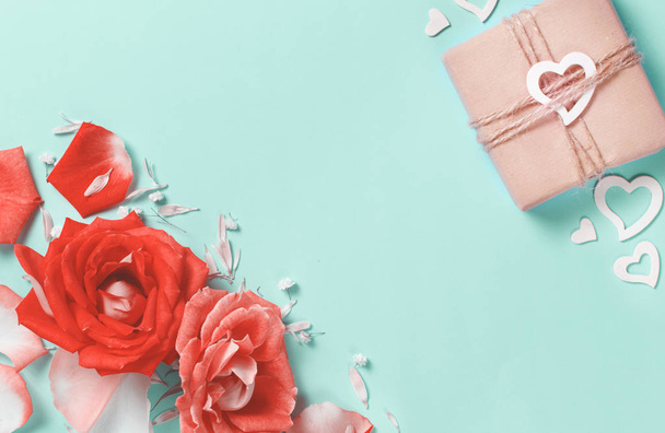 Весенняя композиция с розами, лепестками, сердцами и подарочной коробкой на пастельном фоне
 - Фото, изображение