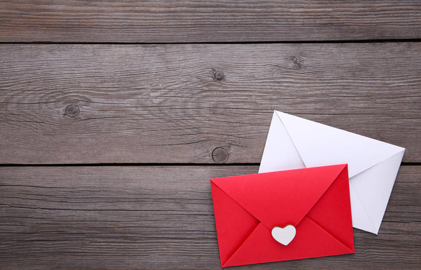 Red and white envelopes with heart on grey background - Fotó, kép