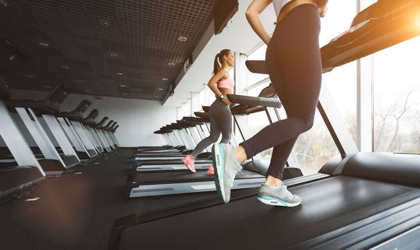 Sportspeople running on treadmill on sunny day - Fotó, kép