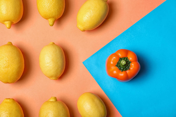 Bell pepper in front of lemons on color background, top view. Be different - 写真・画像