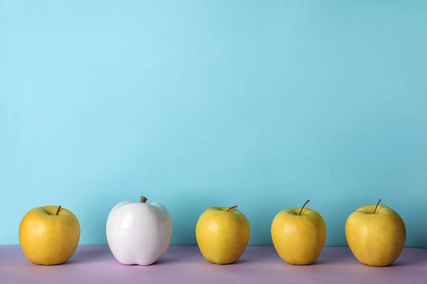 Row of fresh apples with decorative one on color background. Be different - Fotó, kép
