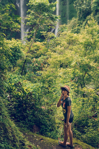 Young woman posing on a great Sekumpul waterfall in the deep rainforest of Bali island, Indonesia. - Foto, imagen