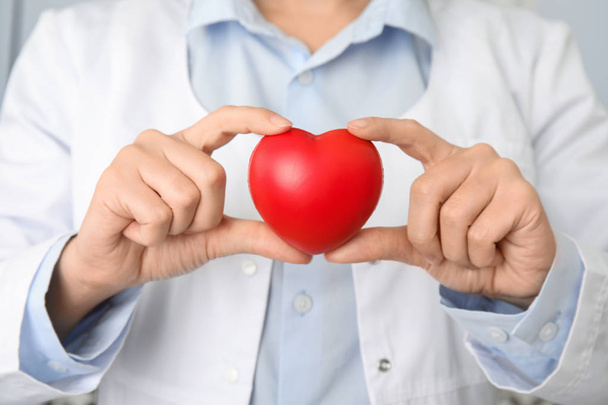 Doctor holding red heart, closeup. Cardiology concept - Fotó, kép