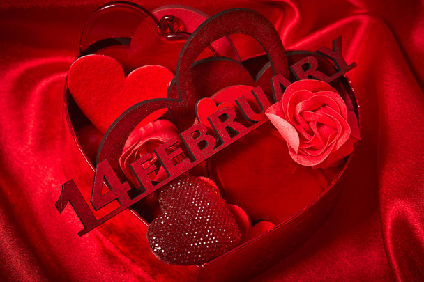 Valentýn dekorace se srdíčky na červené hedvábné tkaniny  - Fotografie, Obrázek