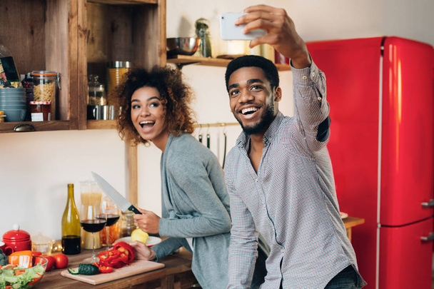 Selfie を取ってキッチンで幸せな若いカップル - 写真・画像