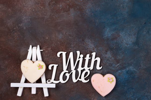 Kekse in Herzform als Sahnehäubchen auf der Staffelei als Bild auf Stein mit Kopierraum, flach liegend. fröhlicher Valentinstag - Foto, Bild
