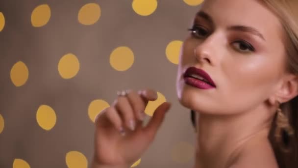 Elegant fashion model with beautiful hair turns face and looks at camera, slow motion - Video