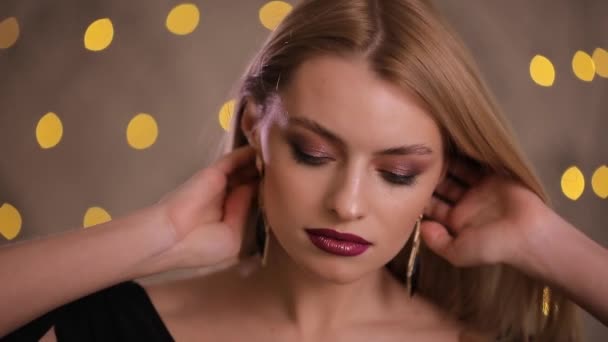 Gorgeous fashion model with beautiful hair posing, slow motion, yellow bokeh background - Imágenes, Vídeo