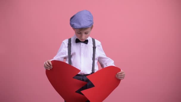 Αγοράκι σε vintage ρούχα προσπαθεί να καθορίσει κόκκινο σπασμένο παιχνίδι καρδιά απλήρωτη αγάπη - Πλάνα, βίντεο