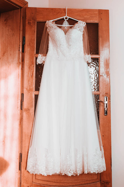 wedding dress on hanger on a wall, Beautiful gown - Foto, Bild