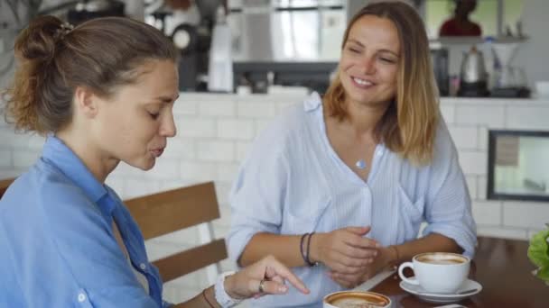 Lesbian couple having date in cafe. Beautiful girls talking while drinking coffee. - Filmati, video