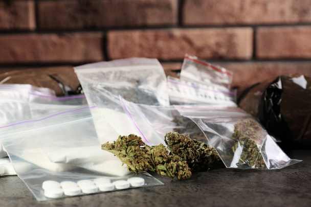 Hemp and other drugs in packages on grey  table - Photo, Image