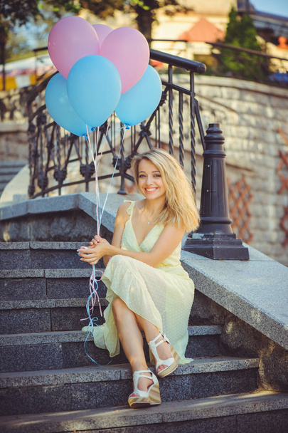 Güzellik kız renkli balonları şehir merdivenlerinde gülüyor. Parlak güneşli bir güzel mutlu genç kadın. Eğleniyor, oyun ve kutlama neşeli modeli pastel renk balon ile - resim - Fotoğraf, Görsel