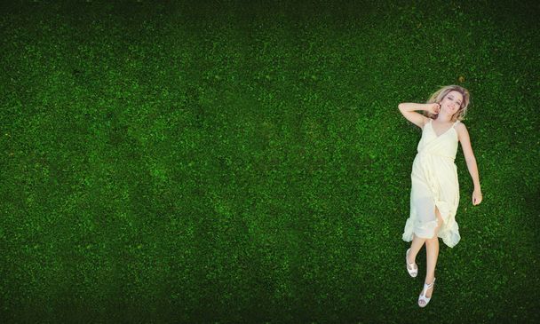 Mooie jonge vrouw liggend op het gras. Verse natuurlijke zomer concept. Bekijk van bovenaf. -afbeelding - Foto, afbeelding