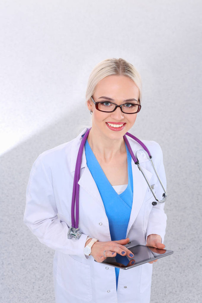 Female doctor using a digital tablet and standing on white background. Woman doctors. - Fotografie, Obrázek