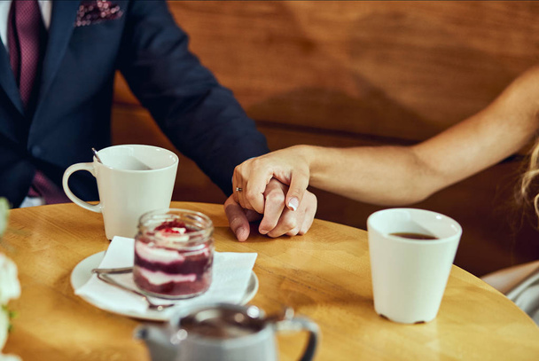 couple drinks coffee with fruit cakes at a cafe - Zdjęcie, obraz